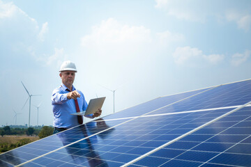 Caucasian mature professional businessman holds laptop computer near solar panels. Engineers...