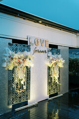 Light stand with bouquets of flowers on the terrace. Caption: Love forever