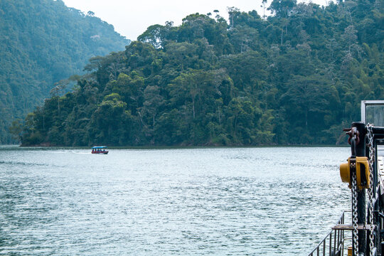boat with tourists on a lake in the middle of mountains and forest on vacation