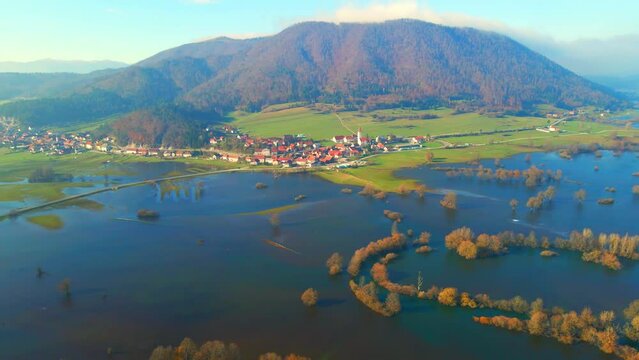 Aerial 4K drone footage of a  Planina plain (Planinsko polje), Slovenia. It was filmed during a rare flooding event. The video shows fields, roads and trees that are surrounded by sheer water.