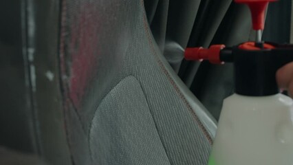 Up close deep clean valeting of auto cloth seat using chemical spray