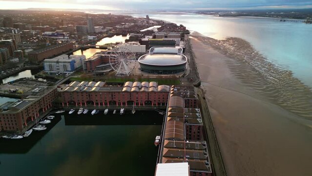 Liverpool Arena, Ferris Wheel and cityscape in golden hour - stunning aerial drone anticlockwise rotate