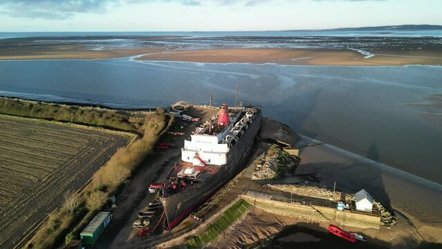 Ghost Ship the Duke of Lancaster at sunset - drone anti-clockwise rotate, reveal estuary - Mostyn, North Wales, UK