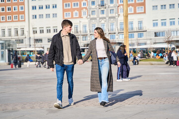 Fototapeta premium two lovers walking hand in hand through the city.