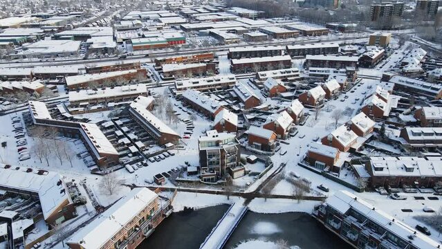 Cinematic aerial of a beautiful suburban neighborhood covered in snow on a sunny day