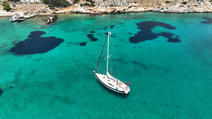 Aerial drone photo of sail boat anchored in paradise bay of Naousa with emerald crystal clear sea,...