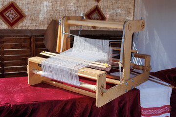 A closeup image of an old weaving Loom and thread of yarn.