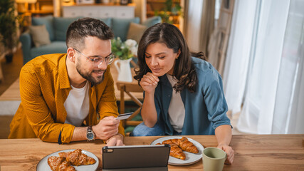 adult happy couple man and woman shopping online hold credit card