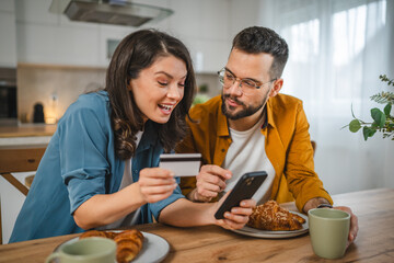 adult happy couple man and woman shopping online hold credit card