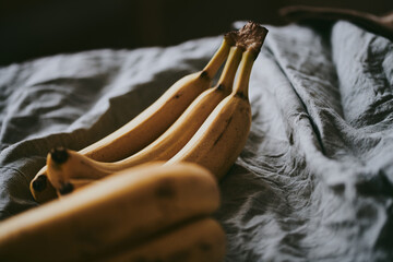 Close-up of a bunch of bananas on a dark fabric background