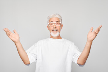Portrait gray-haired man happy face smiling joyfully with raised palms and shocked open mouth isolated on white studio background.