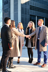Team of business people negotiating an agreement closing the deal with a client at business...
