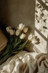 close up of bouquet of white tulips as gift for easter, anniversary, mothers day In pastel spring colours on white bed with shadow isolated in magazine editorial postcard style copy space