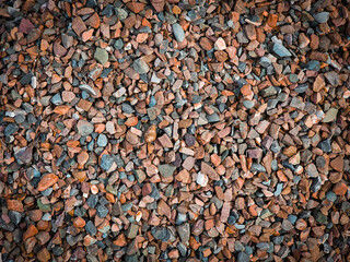 close-up of a gritty texture formed by a mixture of gravel and various stones.Smooth round pebbles texture background.
