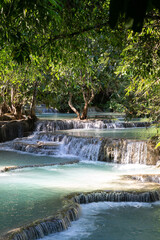 Blue water tropical waterfalls surrounded by lush vegetation