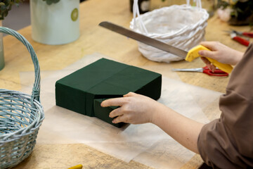 Trimming floral sponge according to size of bouquet basket