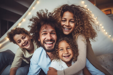 Fototapeta premium Family inside a tent in the living room at night