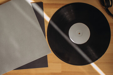 Vinyl record and headphones on a wooden table. Still life on a musical theme.