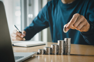 Hand putting coins in a piggy bank for save money and Saving Money concept.