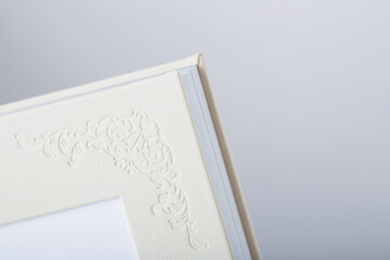 Detail of Wedding photobooks in white leather binding. Wedding photo book, album family album. Photo books with embossing and a cover of genuine leather. Services of a typography and designer.