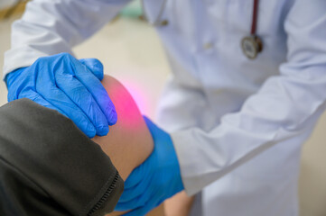 A doctor is examining the knee of a woman who has a knee injury. Foot treatment with an orthopedic...
