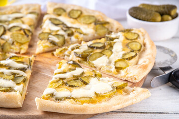 Pickle Pizza with cheese sauce and pickled cucumbers. Trendy asian style, vegan sour taste pizza on kitchen table copy space