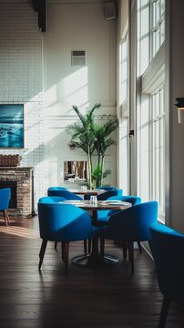 Perfectly composed image capturing the allure of a free photo restaurant private room with blue chairs, white walls, a fireplace, and a wide window letting in natural light
