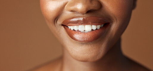 Closeup, lips and black woman with beauty, smile and skincare on a brown studio background. African...