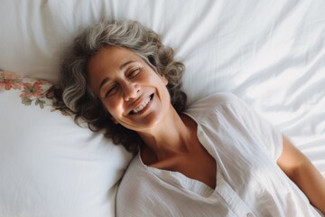Portrait of a smiling senior hispanic woman in bed