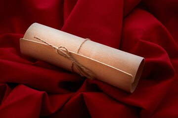A gift wrap tied with a string on a red fabric background. An expensive gift