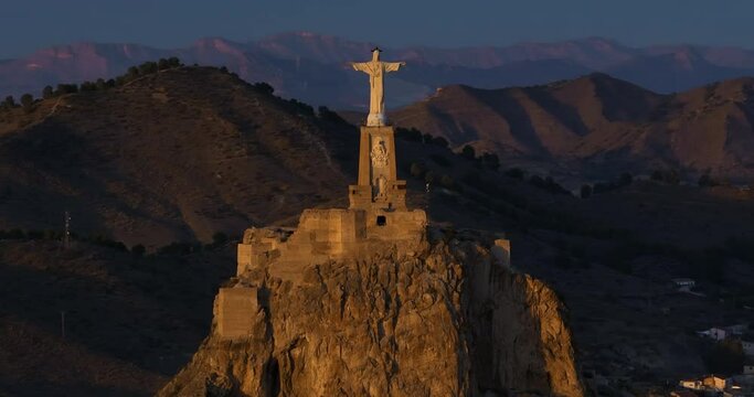 Aerial view traveling out of a statue of Jesus Christ at sunset. Cristo de Monteagudo, Murcia, Spain