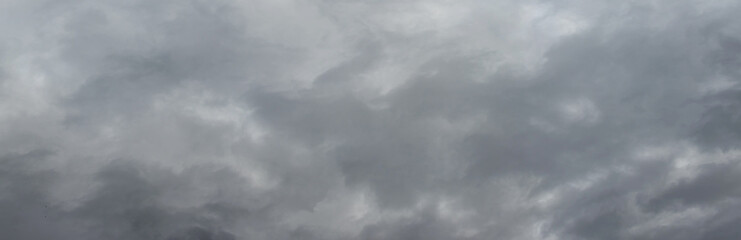 The dark stormy sky is covered with dense gray clouds