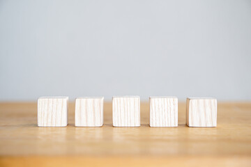 wooden cube or wooden blocks arrange on wooden desk with white background for text replacement or...