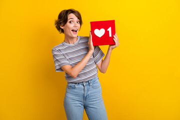 Photo of impressed optimistic woman with bob hairdo dressed striped t-shirt get one social media like isolated on yellow color background