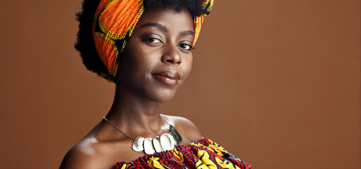Culture, African fashion or face of black woman in studio on a brown background for trendy style....