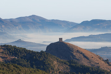Valle de Cocentaina con niebla en la cuenca del río Serpis y torre de vigilancia medieval, España