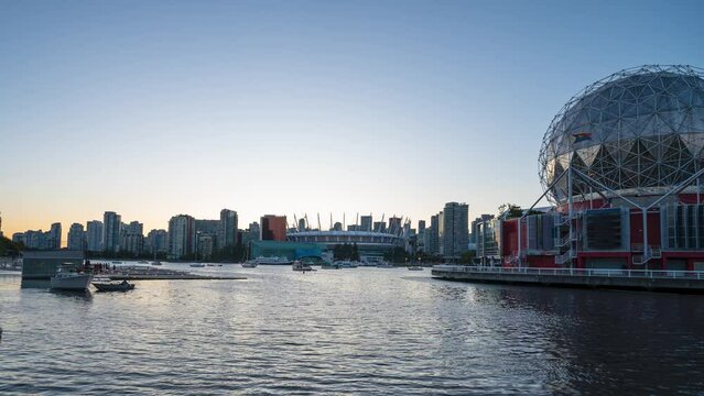 A 4k sunset timelapse of the Vancouver Skyline from False Creek with the Science World Building and the BC Place Stadium illuminated.