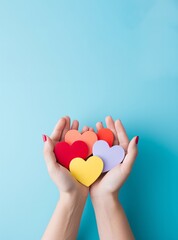 hands holding colorful hearts isolated over blue background.