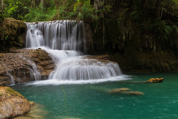 Fototapeta na wymiar Cascading pools at Kuang Xi Waterfall near Luang Prabang, Laos - Beautiful turquoise blue waterfalls in Asia.