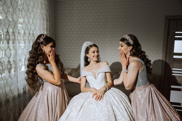 A beautiful bride and her bridesmaids are having fun in the morning. Wedding celebration. Happy...