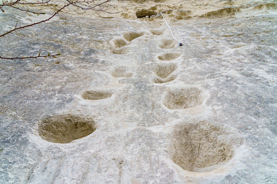 Foot recesses for climbing in limestone rock. Background with selective focus and copy space - Powered by Adobe