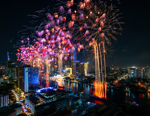 Fototapeta premium Nighttime Celebration: Vibrant Fireworks Illuminate the City Skyline in a Beautiful Display of Color and Light during a Festive Event in Thailand