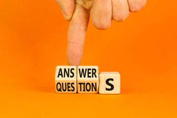 Q and A questions and answers symbol. Turned wooden cubes and changed the word questions to answers. Beautiful orange background, copy space. Business Q and A questions and answers concept.