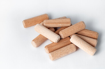 Pile of wooden dowels on the white background.