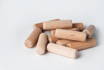 Pile of wooden dowels on the white background.