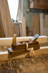 Carpentry tool. Hand plane. Old tools. Joinery tool. Wood shavings, chip. Wooden table and boards, rails