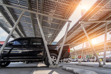 Car parking with canopy roof with solar panels. Solar power generation. Black pickup car with body