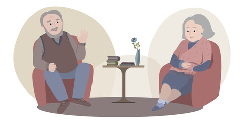 Couple of pensioners sitting in armchairs opposite each other. Man is speaking, woman is listening. Coffee table with books and vase with flower is between armchairs.