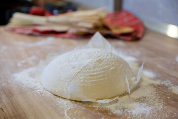 Shaping the sourdough. Shaping a home made bread dough after the first rise. Home made fresh bread making process. Selective focus.