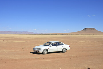 Fototapeta na wymiar Car in the desert on a bright sunny day, recreation and tourism